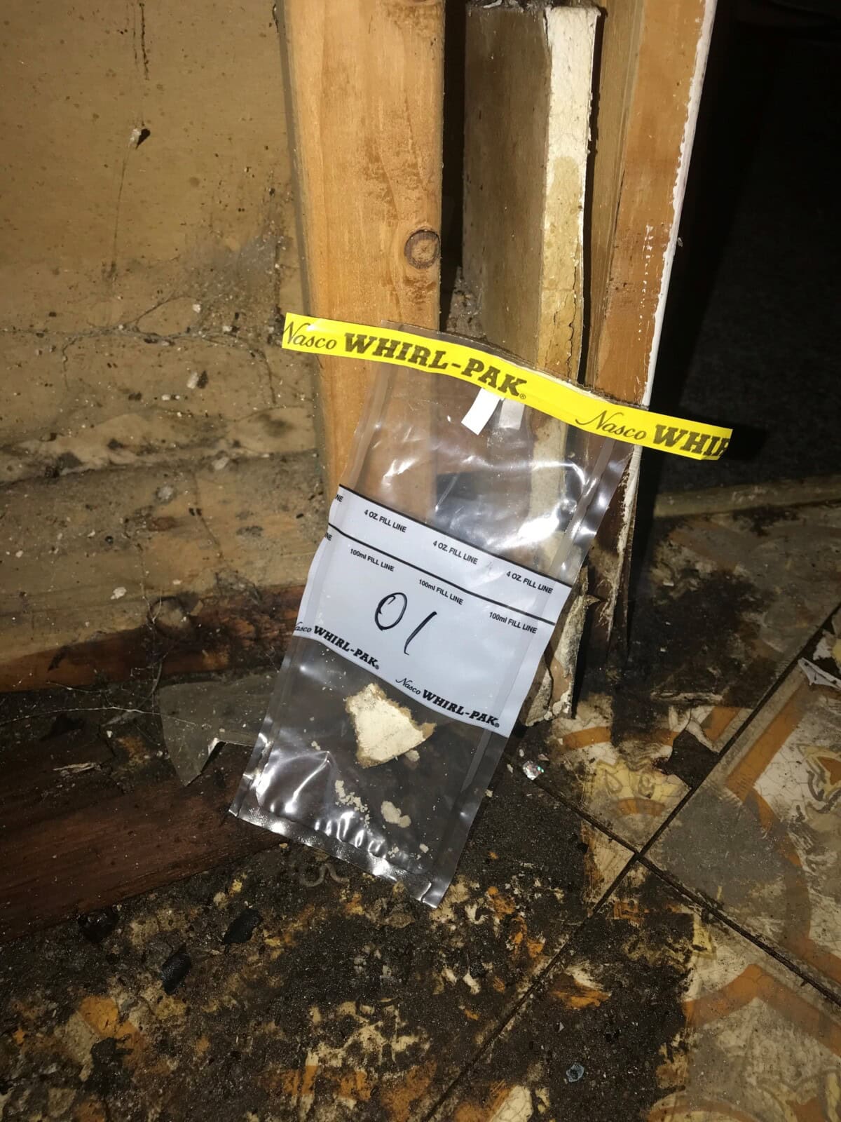 A note taped to the wall of a room with water damage.