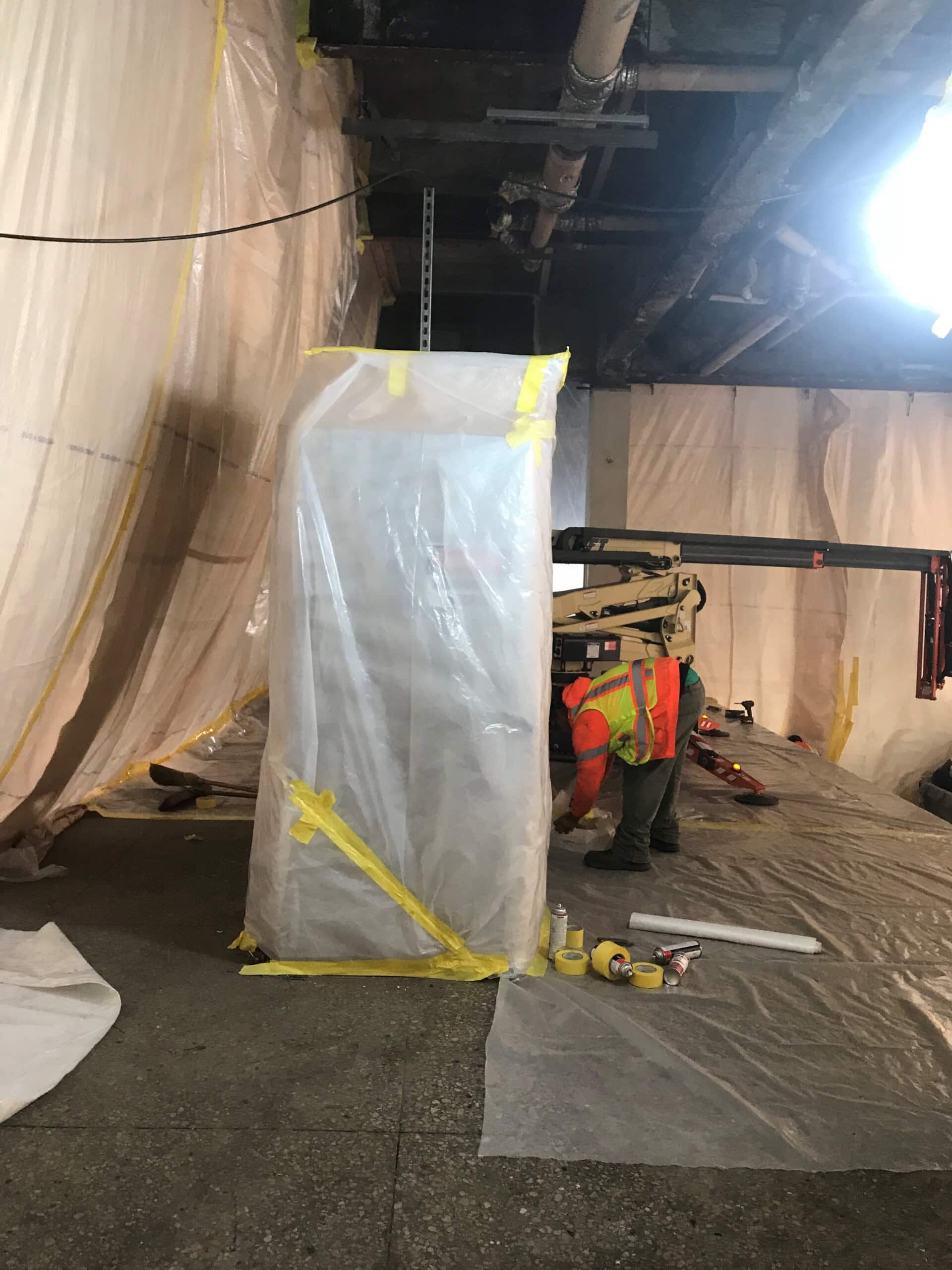 A ceiling with insulation and wires hanging from it.