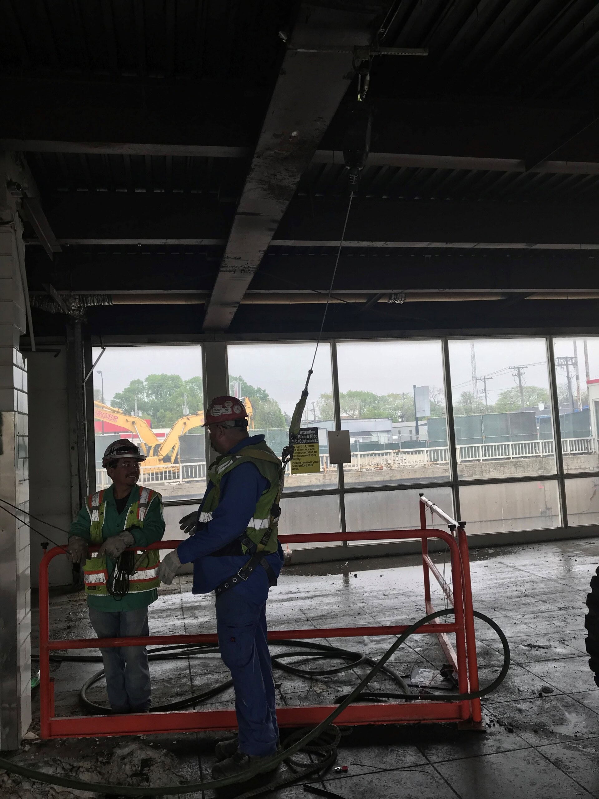 Two men in safety gear are working on a construction site.